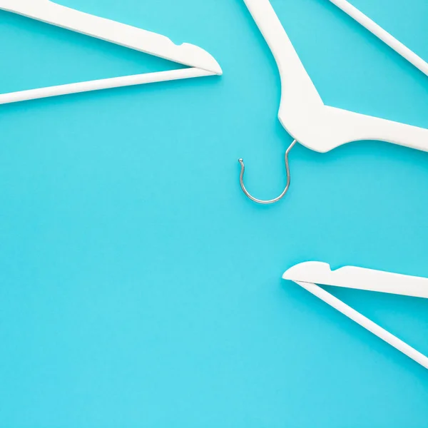 White wooden hangers on blue background — Stock Photo, Image