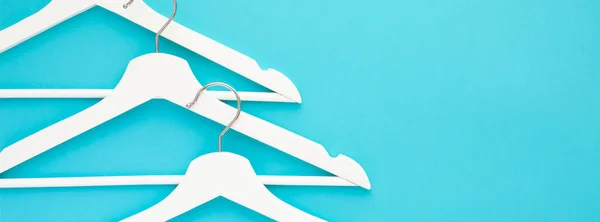 White wooden hangers on blue background — Stock Photo, Image