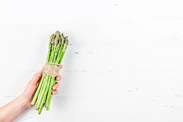 Verse groene asperges in vrouwenhanden — Stockfoto