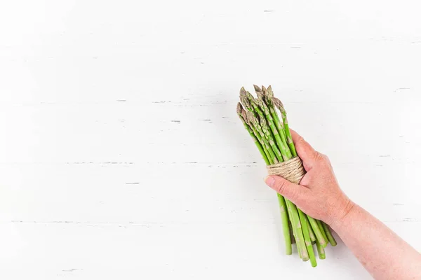 Fresh green asparagus in woman hands — ストック写真