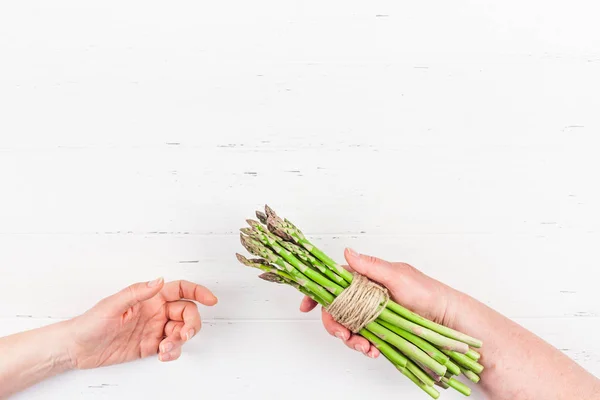 Fresh green asparagus in woman hands — ストック写真