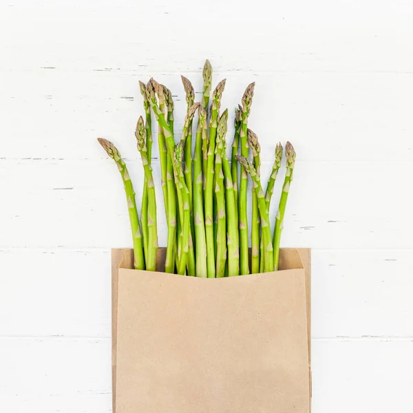 Verse groene asperges op witte houten ondergrond — Stockfoto