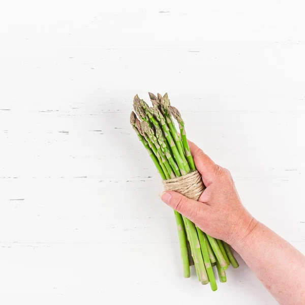 Asparagi verdi freschi nelle mani delle donne — Foto Stock