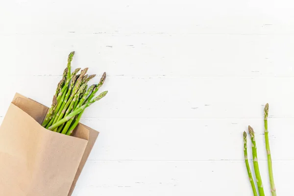 Verse groene asperges op witte houten ondergrond — Stockfoto