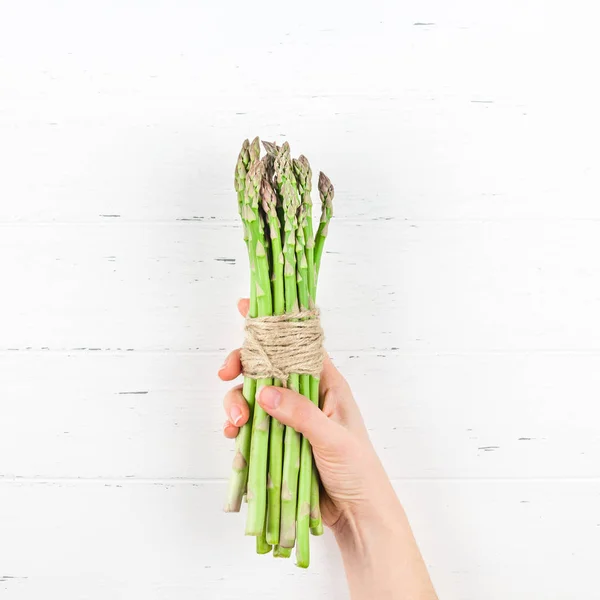 Espargos verdes frescos em mãos de mulher — Fotografia de Stock