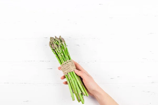 Espargos verdes frescos em mãos de mulher — Fotografia de Stock