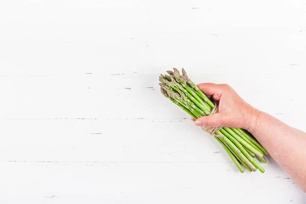 Asparagi verdi freschi nelle mani delle donne — Foto Stock