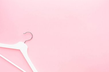 Pastel pembe arka planda beyaz askılar