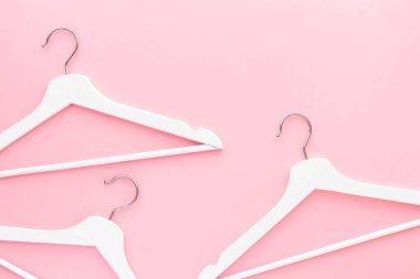Pastel pembe arka planda beyaz askılar