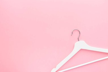 Pastel pembe arka planda beyaz askılar
