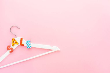 Pembe arka planda satılık metin ile beyaz askıları