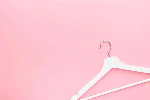 White hangers on pastel pink background — Stock Photo, Image