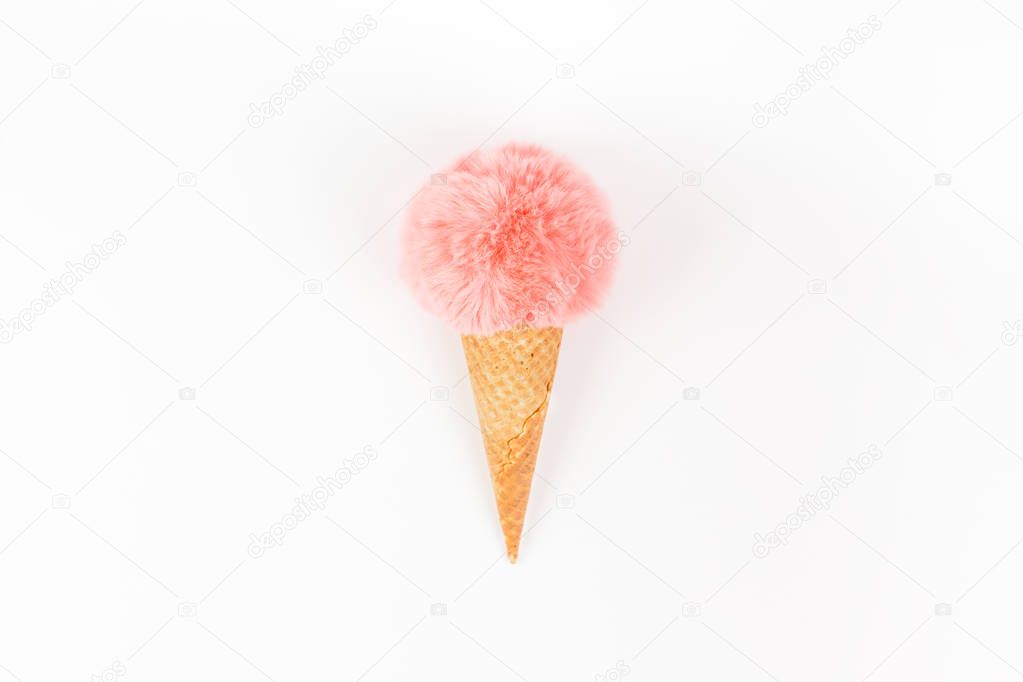 Coral fur ball in waffle cone on white background