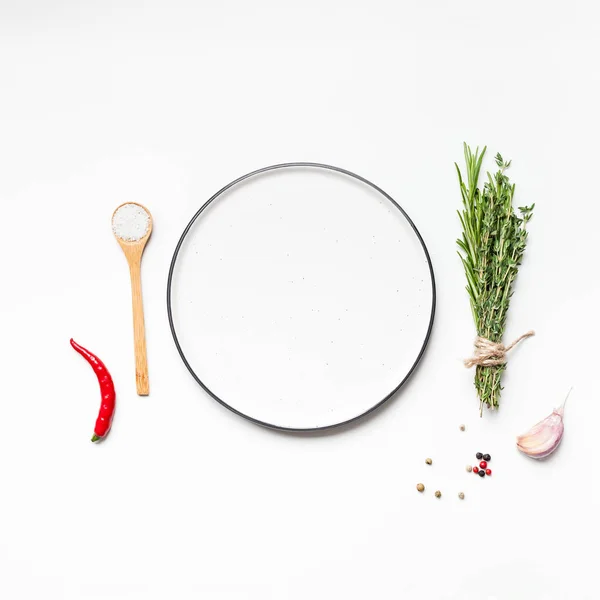 Empty plate with greens herbs and spices around — Stock Photo, Image