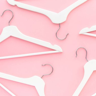 Pastel pembe arka planda beyaz askılar