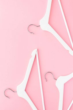 Pastel pembe arka planda beyaz askılar