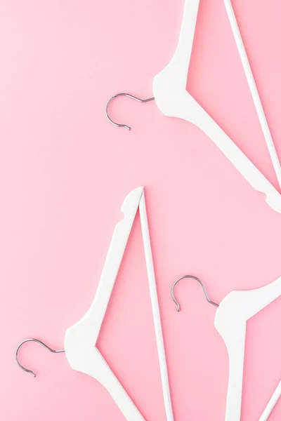 Perchas blancas sobre fondo rosa pastel — Foto de Stock