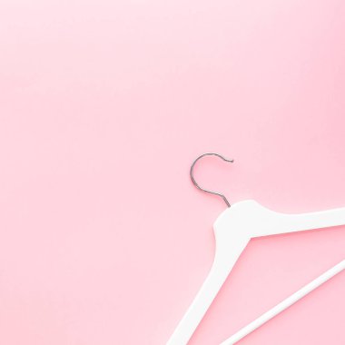 Pastel pembe arka planda beyaz askılar