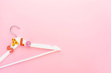 Pembe arka planda satılık metin ile beyaz askıları