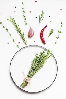 Yeşillik otlar ve baharatlar etrafında Boş plaka