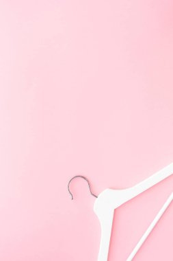Pastel pembe arka planda beyaz askılar
