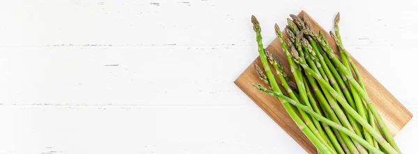 Verse groene asperges op witte houten ondergrond — Stockfoto