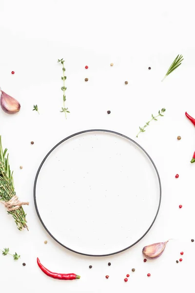 Empty plate with greens herbs and spices around — Stock Photo, Image