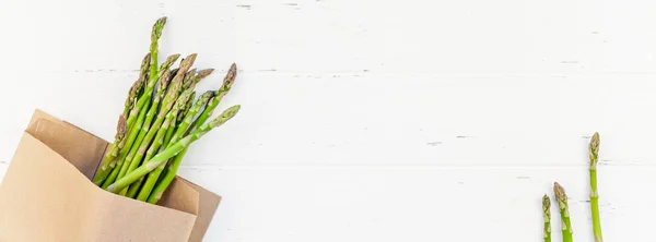 Espargos verdes frescos sobre fundo de madeira branco — Fotografia de Stock