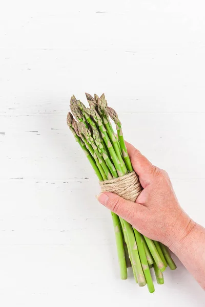 Fresh green asparagus in woman hands — Stock Photo, Image