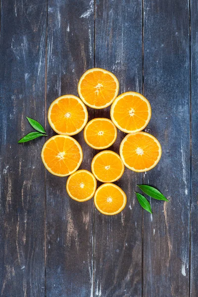 Свежие апельсины на темном деревянном фоне — стоковое фото