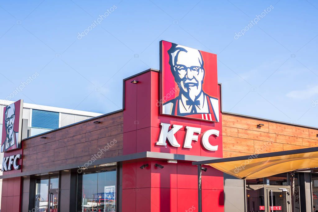 SAGUNTO, SPAIN - FEBRUARY 08, 2019: KFC fried chicken fast food restaurant logo at its building located in Sagunto shopping area, Spain. Clear bright blue sky