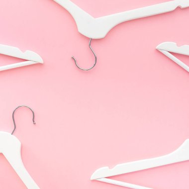 Pastel pembe arka planda beyaz askılar