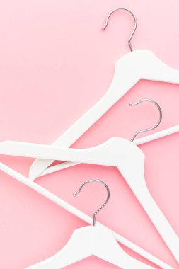 Pastel pembe arka planda beyaz askılar