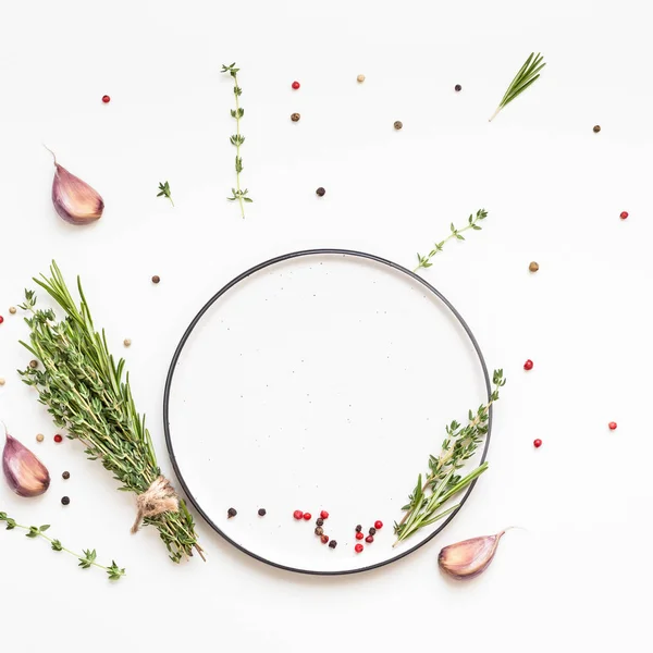 Empty plate with greens herbs and spices around — Stock Photo, Image