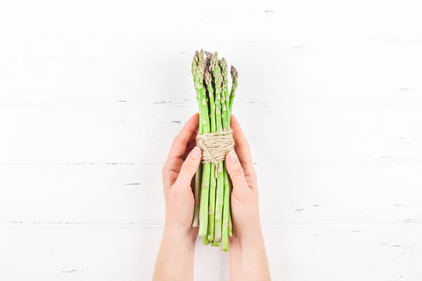 Fresh green asparagus in woman hands — ストック写真