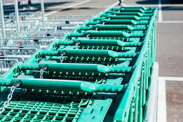 Linha de carrinhos de compras verdes em um supermercado — Fotografia de Stock