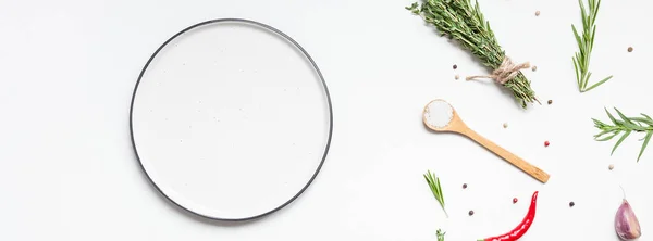 Empty plate with greens herbs and spices around — Stock Photo, Image