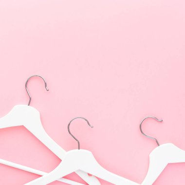 Pastel pembe arka planda beyaz askılar
