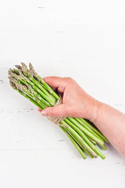 Fresh green asparagus in woman hands — ストック写真