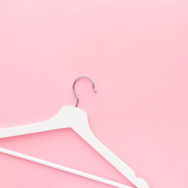 Pastel pembe arka planda beyaz askılar