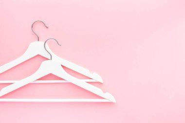Pastel pembe arka planda beyaz askılar