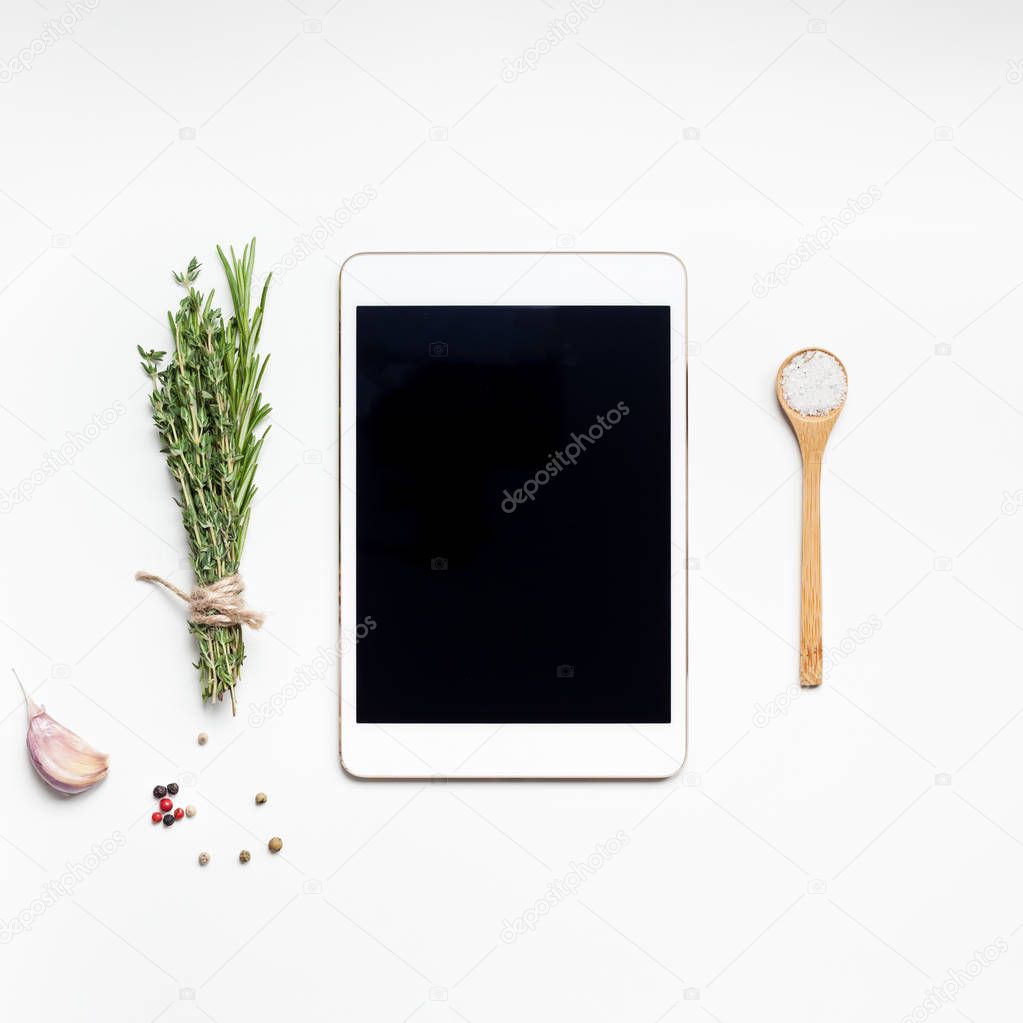 Empty tablet PC with greens herbs and spices