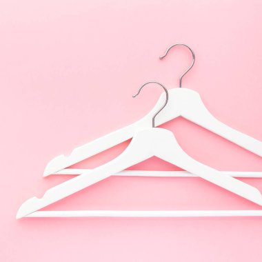Pastel pembe arka planda beyaz askılar