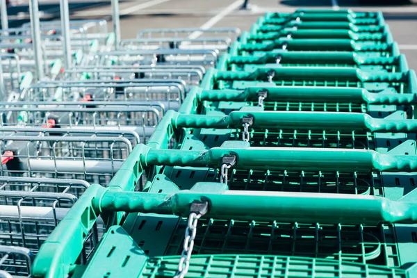 Linia zielonych wózków sklepowych w supermarkecie — Zdjęcie stockowe