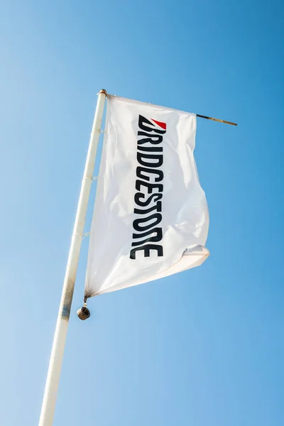 Bridgestone Flagge mit Logo auf blauem Himmel Hintergrund — Stockfoto