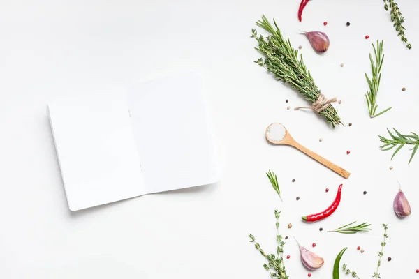 Blank notepad pages with greens herbs and spices