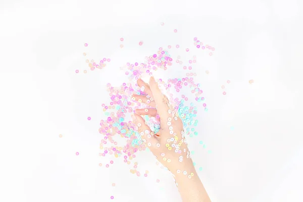 Perlen-Pastell-Konfetti funkelt mit Frauenhand — Stockfoto