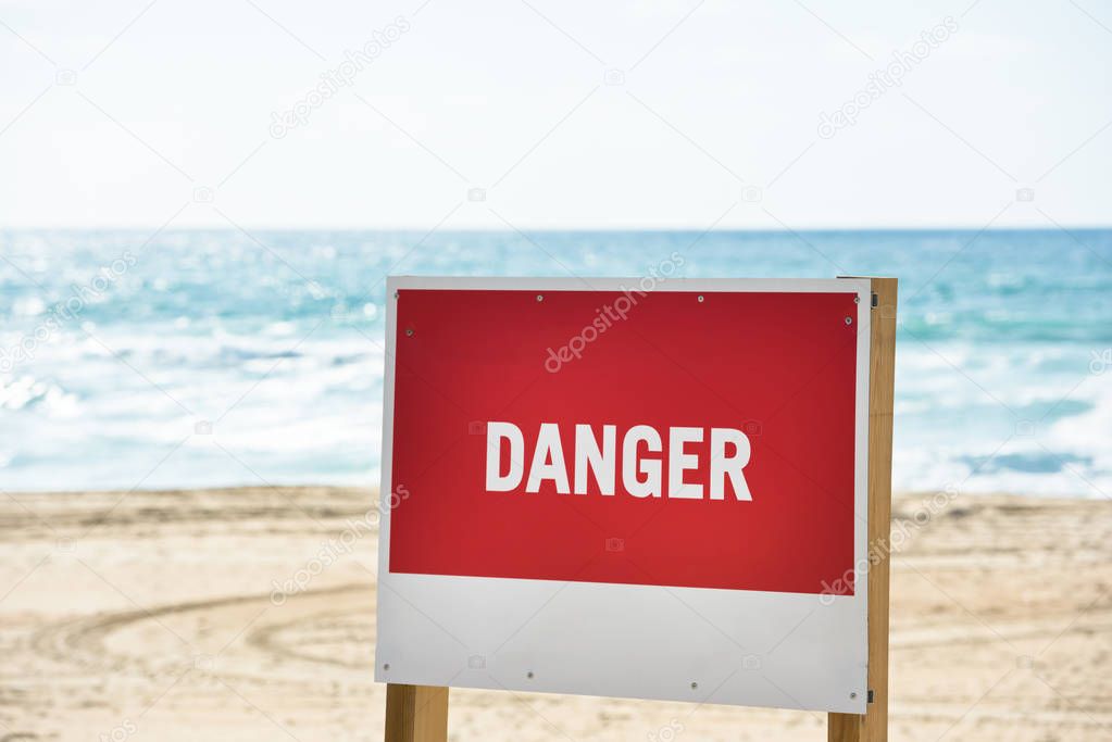 Red danger sign on an ocean beach