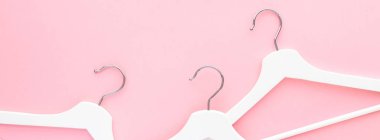 Pastel pembe arka planda beyaz askılar