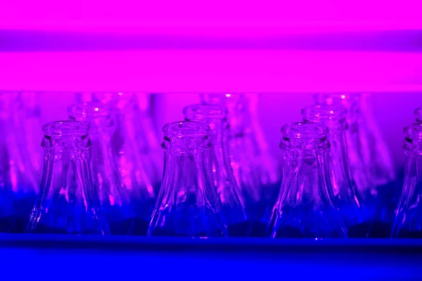 Neonfarbener Kunststoffkasten mit leeren Glasflaschen — Stockfoto